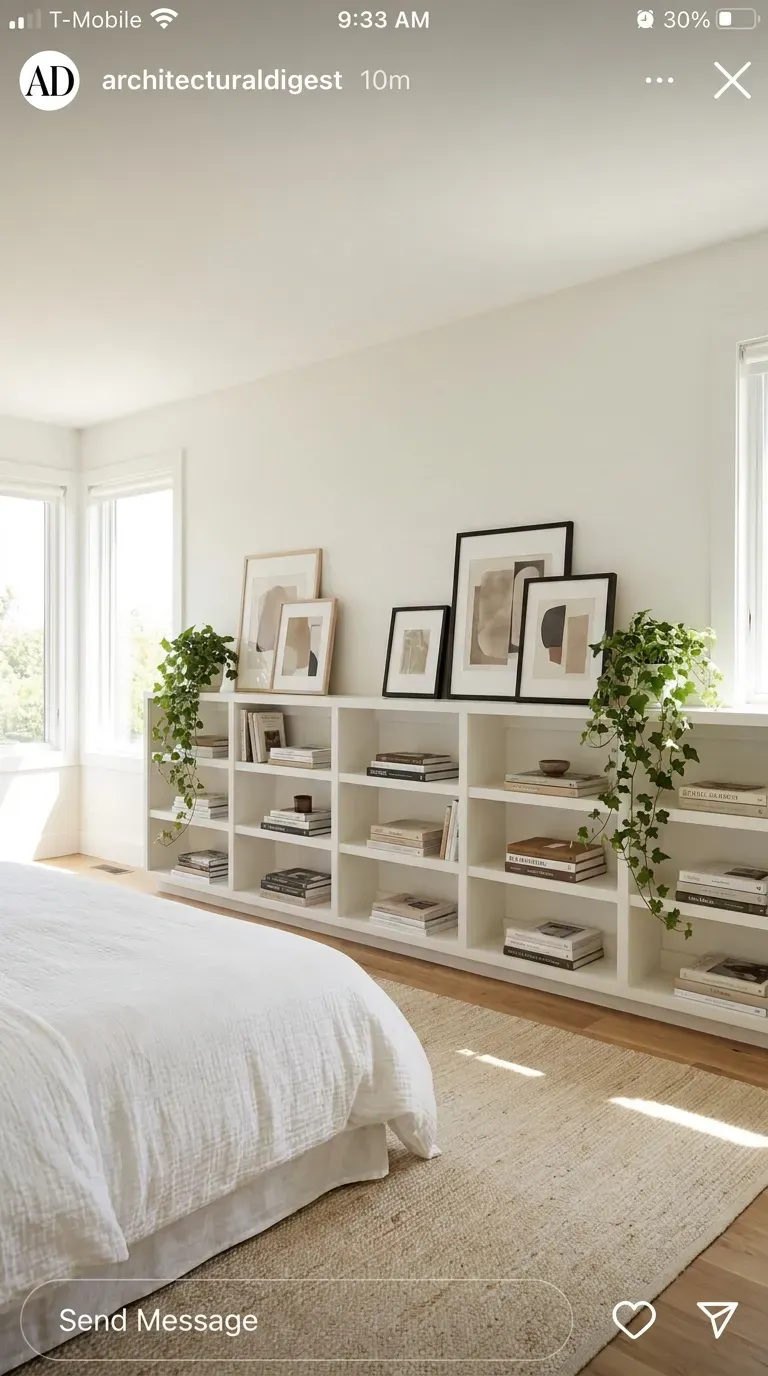 A wall of low-profile bookshelves opposite a bed